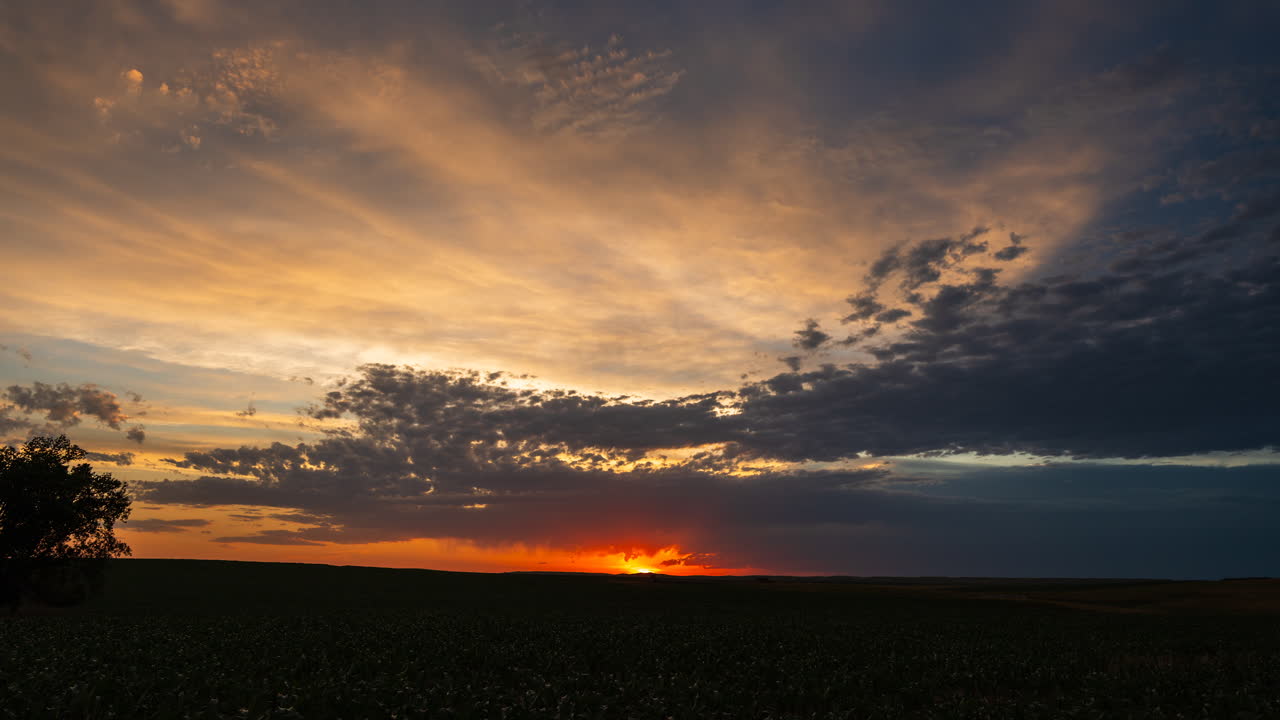 Warmer Sonnenuntergangshimmel mit geschichteten Wolken, die eine heitere und filmreife Naturkulisse schaffen