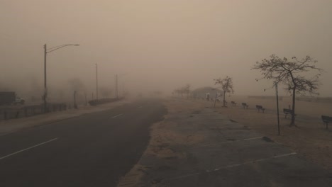 Pushing-forward-along-a-sandy-street-during-heavy-mist