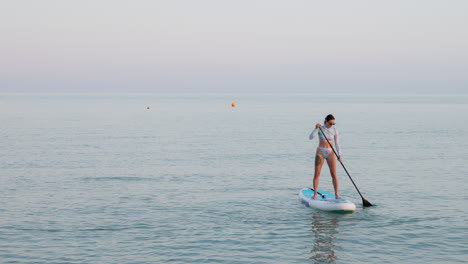 mujer paddleboarding en aguas tranquilas