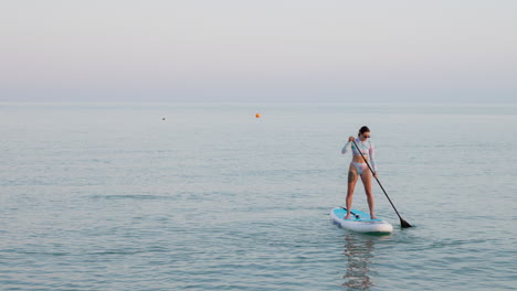 woman paddleboarding in calm waters