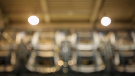 Handheld-camera-view-of-an-industrial-warehouse,-rows-of-neatly-stacked-car-parts,-high-ceiling-with-exposed-pipes-and-beams