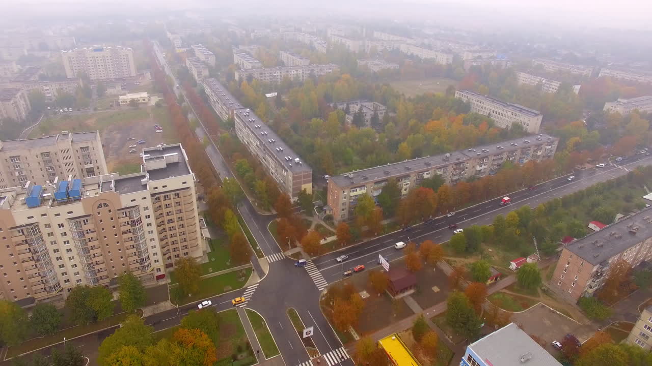 Crossroads with few cars in the city. Top view of the usual Ukrainian city on foggy autumn day.