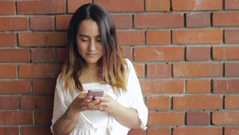 mujer joven enviando mensajes de texto a su teléfono móvil