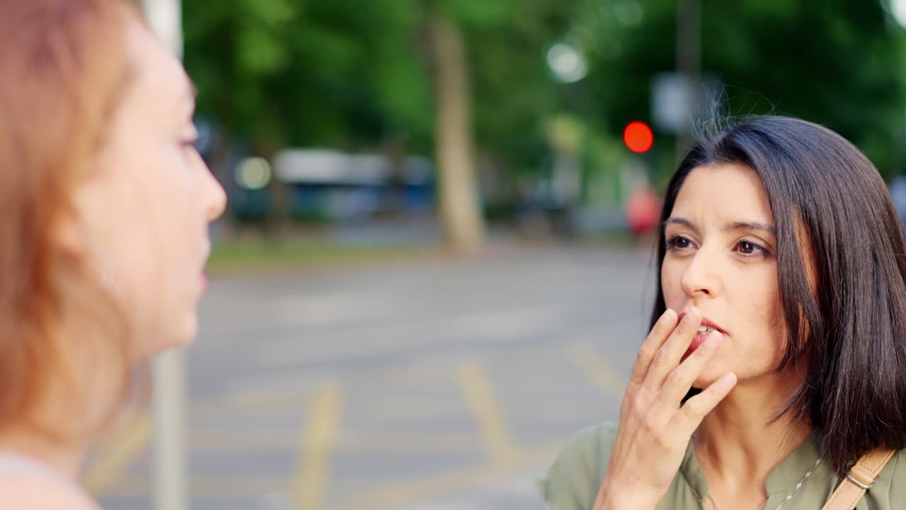 두 여인이 야외에서 대화를 나누고 있다