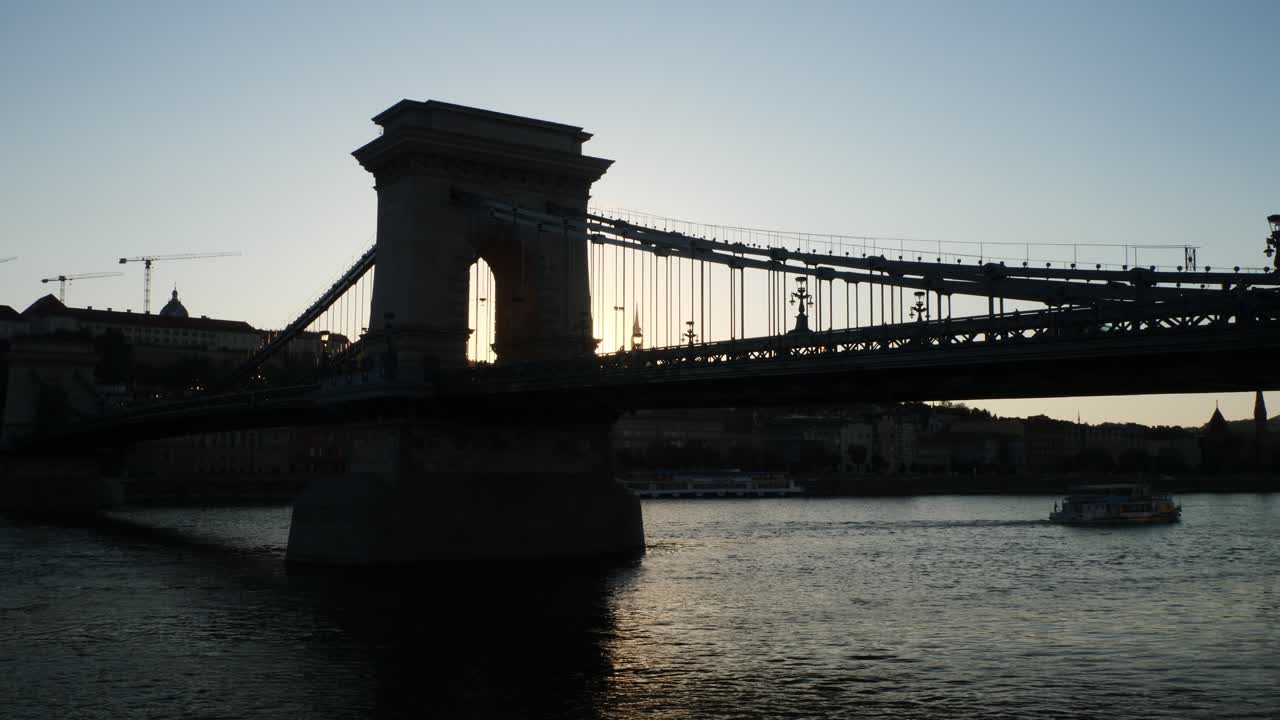 Silhouette der Kettenbrücke mit einem Flusskreuzfahrtschiff im Hintergrund, Budapest, Ungarn