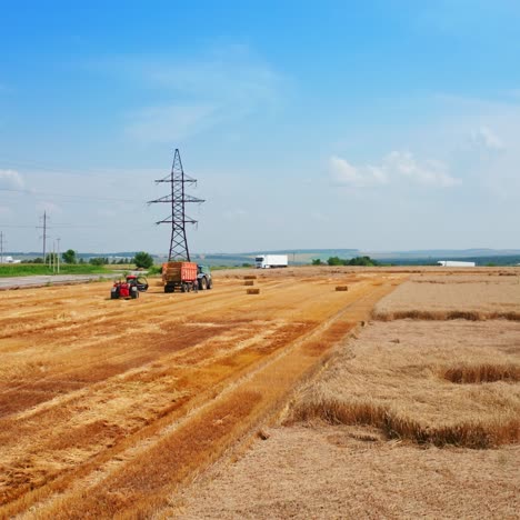 Scenic picturesque plantation on summer harvest season. Machinery in the field picking the hay bales after mowing the crops