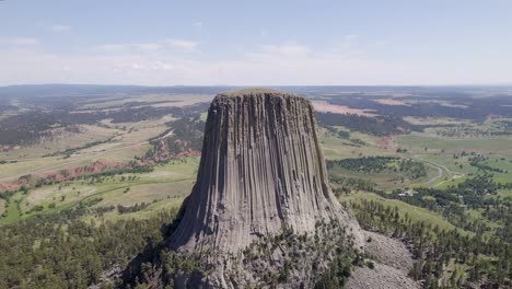 A-drone-shot-of-Devils-Tower,-a-massive,-monolithic,-volcanic-stout-tower,-or-butte,-located-in-the-Black-Hills-region-of-Wyoming