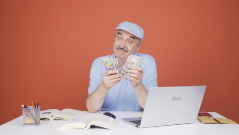 Old-man-looking-at-laptop-counting-money.