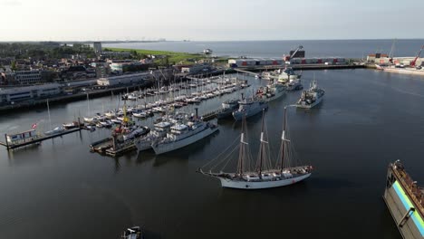 port in the netherlands with naval ships and tall ships