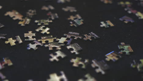a partially solved puzzle sits amongst the other pieces on a felt mat