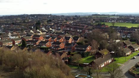 Rural-British-townhouse-neighbourhood-homes-with-green-space-aerial-view-across-to-Snowdonia-mountain-skyline,-Pull-away-shot