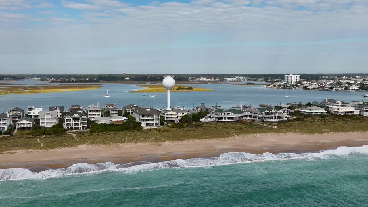 해변과 급수탑에 있는 호텔 위를 비행하는 항공 영상