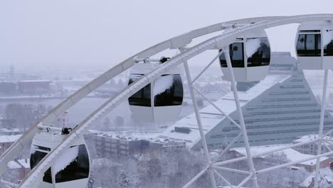 Latvia’s capital in winter with snowbound ferris wheel and distant old town