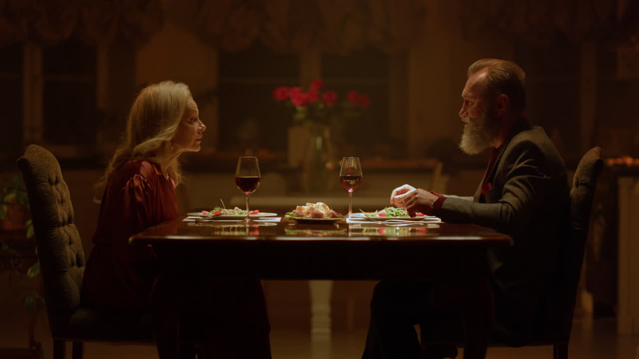 편안한 성숙한 커플  ⁇ 만적 인 데이트 저녁 집. 할아버지와 할머니가 잔을 틀고