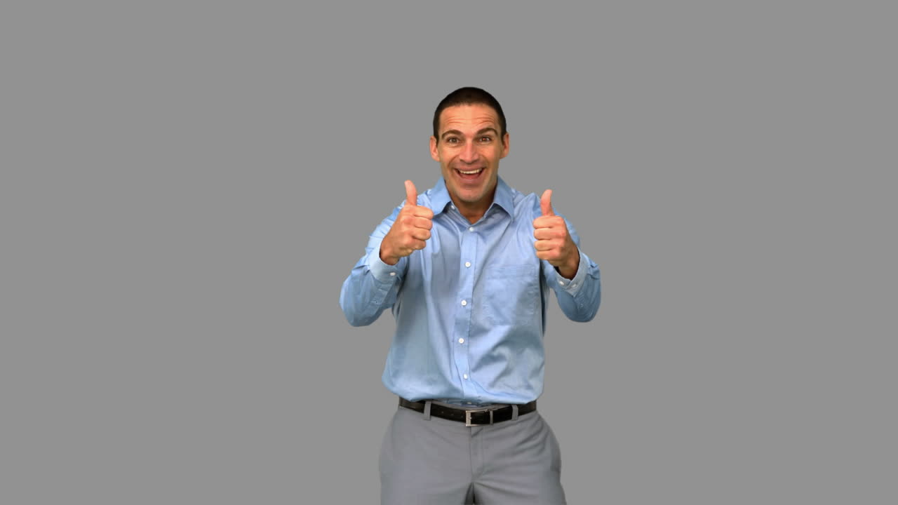 hombre de negocios alegre dando pulgares hacia arriba en la pantalla gris
