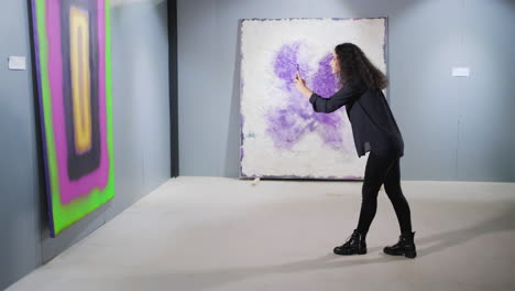 woman taking photos of abstract art in a gallery