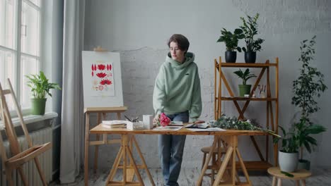 artist painting flowers in a studio