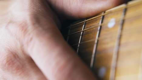 confused rock musician holds hand on brown acoustic guitar