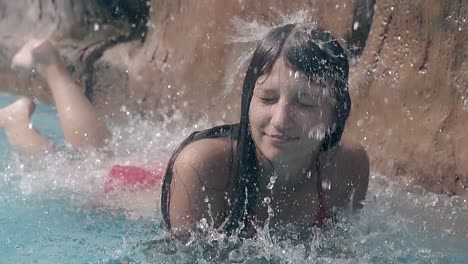 smiling lady rests at artificial waterfall slow motion