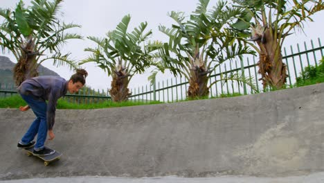 Side-view-of-young-caucasian-man-practicing-skateboarding-on-ramp-in-skateboard-park-4k