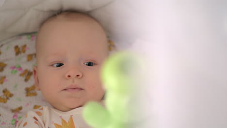 Active-six-months-baby-girl-playing-with-toys-in-crib