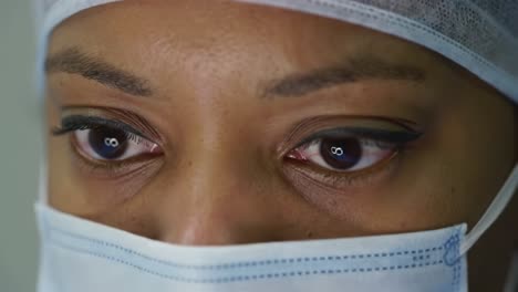 close-up of a health professional’s eyes depicting focus and determination behind a surgical mask in a clinical setting
