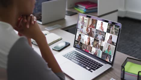 african american woman having a video conference on laptop with office colleagues at office