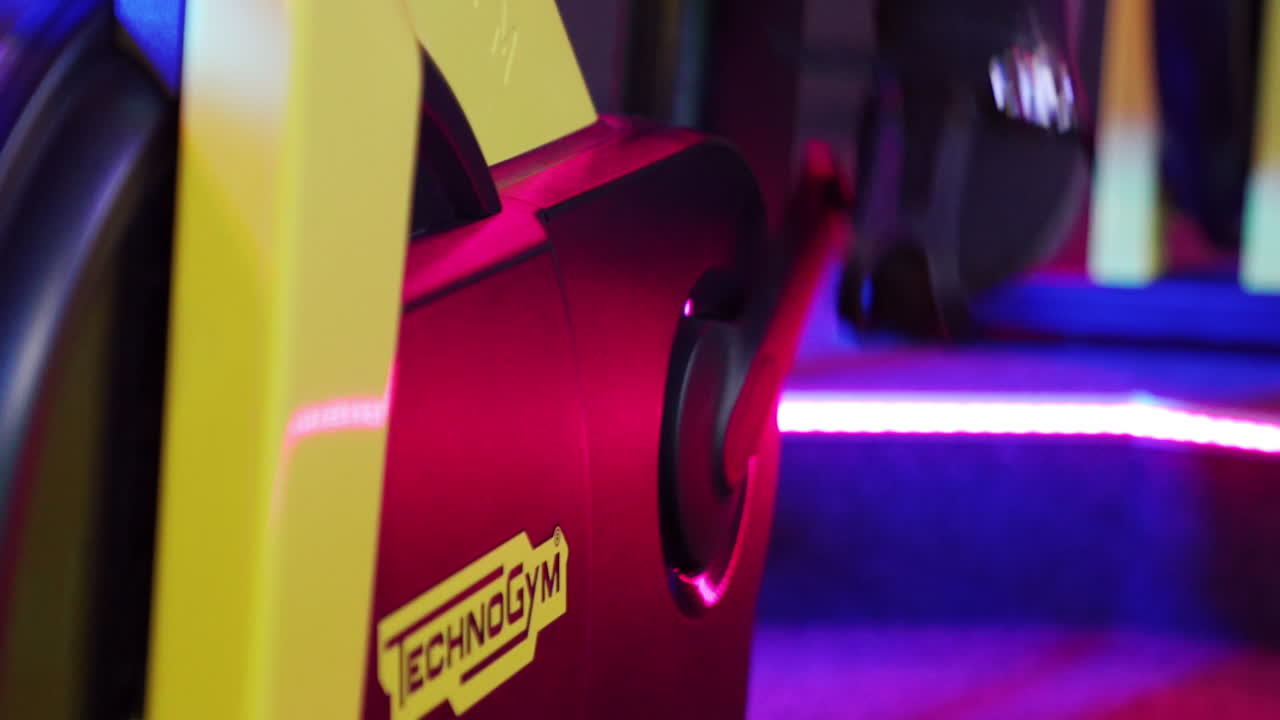 Man training on spin bikes. Sportsman bodybuilder ride stationary exercise bike machine for bodybuilding at fitness