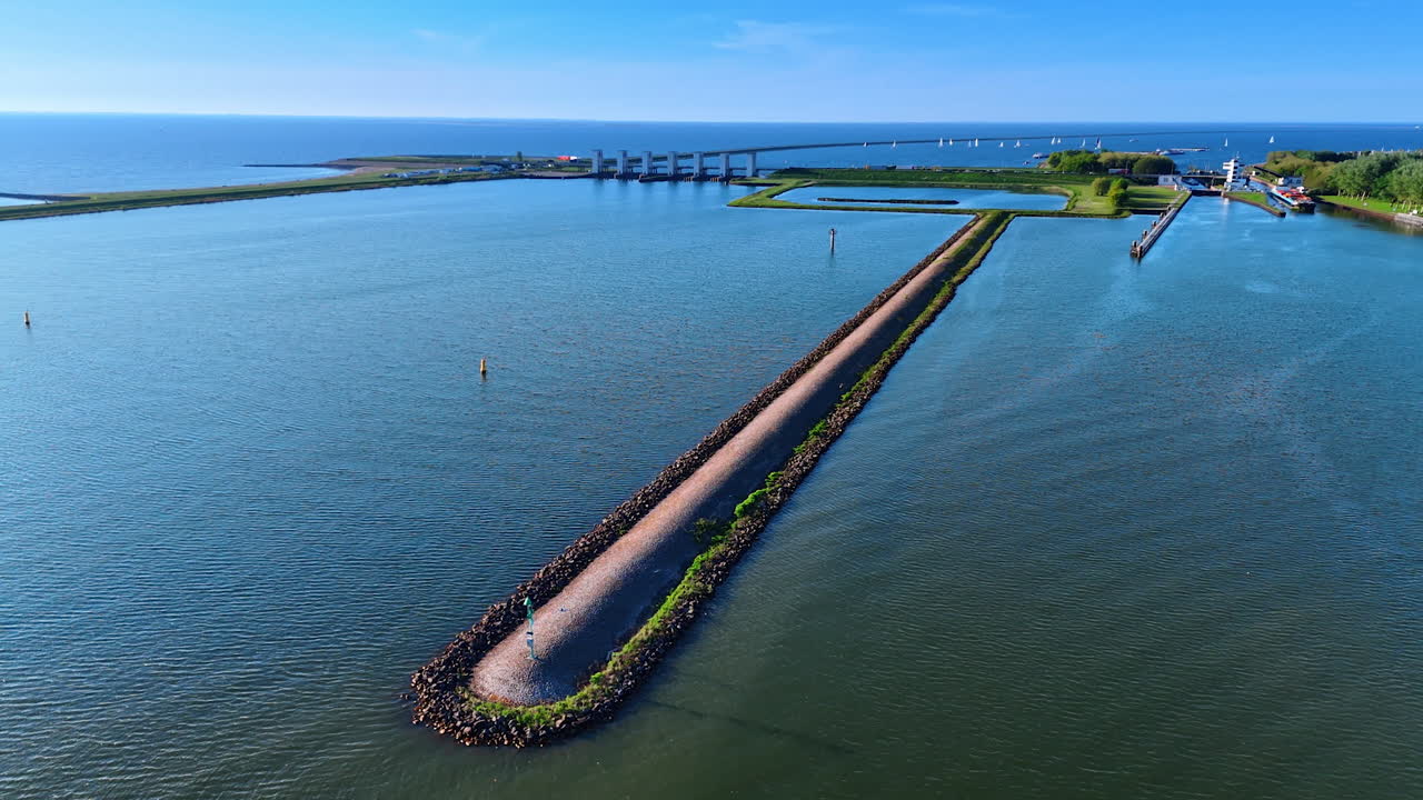 Dams on the beautiful blue waterscape. Drone flight approaching sluice on the dike in the marina of Lelystad, the Netherlands.