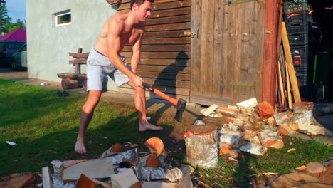 young man splitting wood with an axe