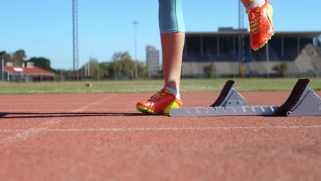 Unterer-Teil-Einer-Sportlerin,-Die-Auf-Einer-Laufstrecke-Am-Sportort-4k-Die-Startposition-Einnimmt