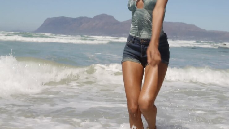 Woman dancing on beach in the sunshine 4k