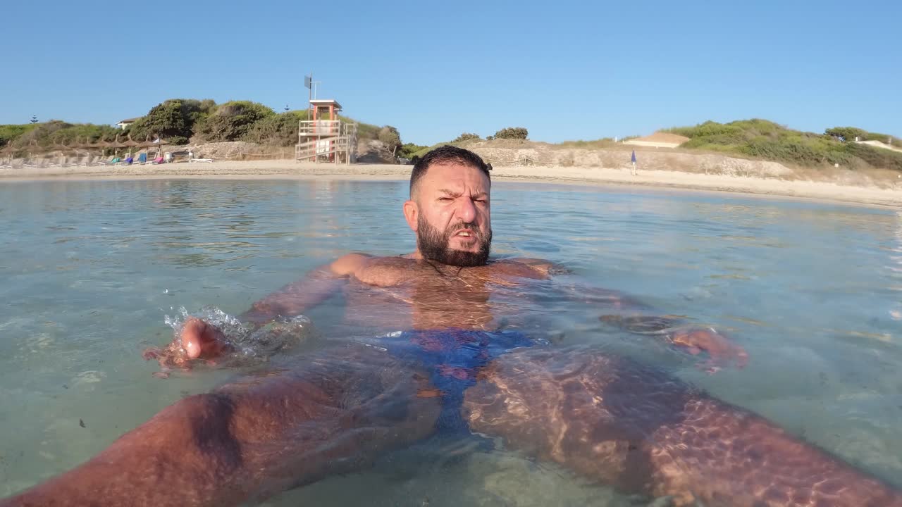 hombre bañándose en la orilla de la playa