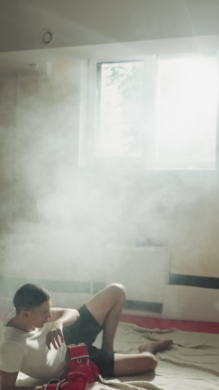 피곤한 남성 운동선수 그룹은 힘든 권투 세션 후에 휴식을 취합니다. 신체 활동으로 인한 피로. 전투 스포츠에 참여하고 스포츠 클럽에서 힘을 향상시니다.