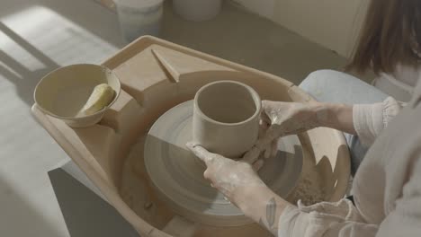 a female ceramicist doing pottery on the wheel