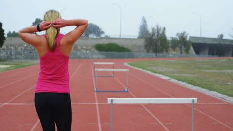 vista trasera de una atleta caucásica caminando en la pista de atletismo 4k