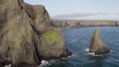 Aerial-approaching-shot-of-Ketubjorg-Cliffs-with-water-of-ocean-in-Iceland---Beautiful-rocky-coastline-of-Iceland,-Europe-at-sunset