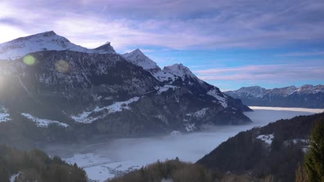 mountains in winter. in the valley you can see the sea of ​​fog moving. the sun is setting and clouds are passing by in the sky