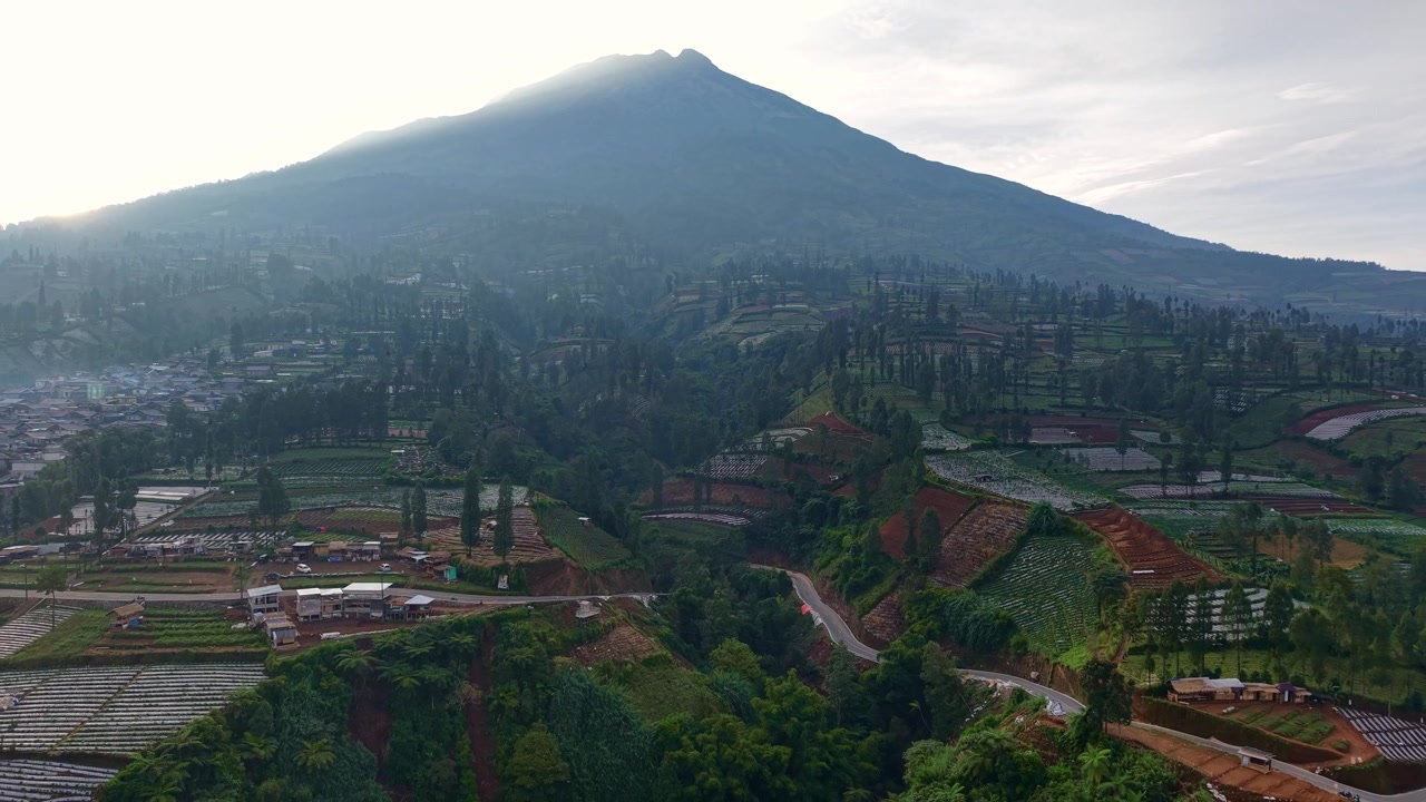 Vista aérea de carretera sinuosa en ladera de montaña, paisaje de tierras de cultivo exuberantes, campo pintoresco, destino de viaje, entorno natural. Paisaje rural de Indonesia
