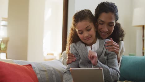 Glückliche-Gemischtrassige-Mutter-Und-Tochter-Sitzen-Auf-Dem-Sofa,-Haben-Spaß-Und-Benutzen-Das-Tablet