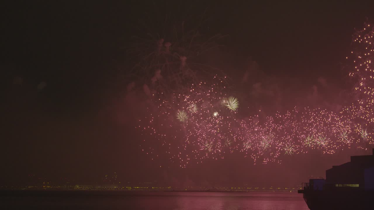 Slow-motion of large scale fireworks illuminating corniche of Doha on Qatar National day.