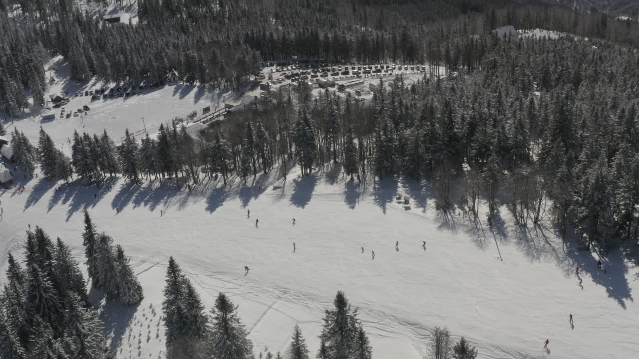 Pista Ribnica presso la stazione sciistica Kope in Slovenia con sciatori in discesa, riprese aeree con panoramica a sinistra