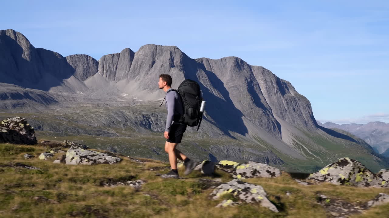 Uomo con zaino che fa trekking in un paesaggio montano panoramico