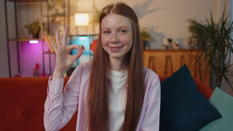 happy cheerful child girl kid looking approvingly at camera showing ok gesture, positive like sign