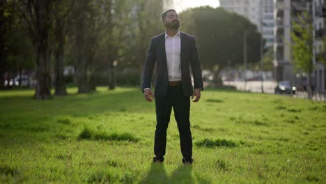 happy businessman standing on green lawn