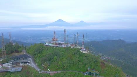 Telomoyo-mountain-in-horizon-and-cell-towers-in-foreground,-aerial-drone-view