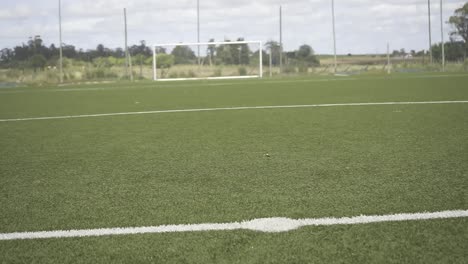 lush green soccer field with white lines and a goal post, ready for a match under a bright sky