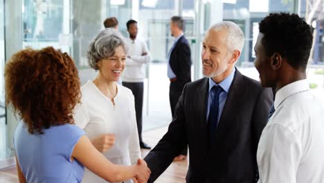 businesspeople shaking hands in office