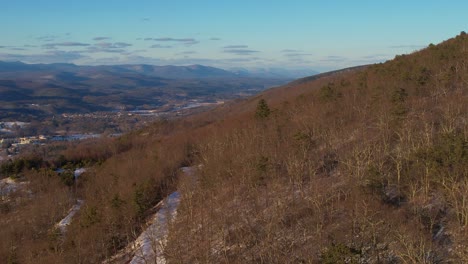 aerial drone footage of a beautiful, colorful sunset of the snowy appalachian mountains during winter