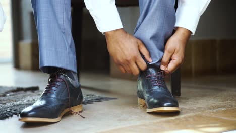 groom putting on shoes at his wedding